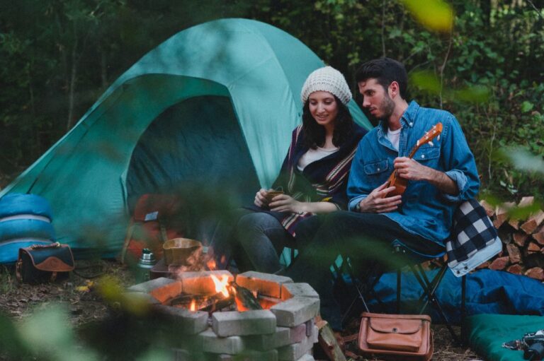 attractive-young-couple-sitting-by-a-campfire-and-tent-.jpg